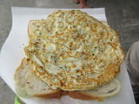 They put the patty on grilled bread.  It is then sprinkled with smoked salt and lemon.  It tastes like a combo between fried fish and egg foo yung.